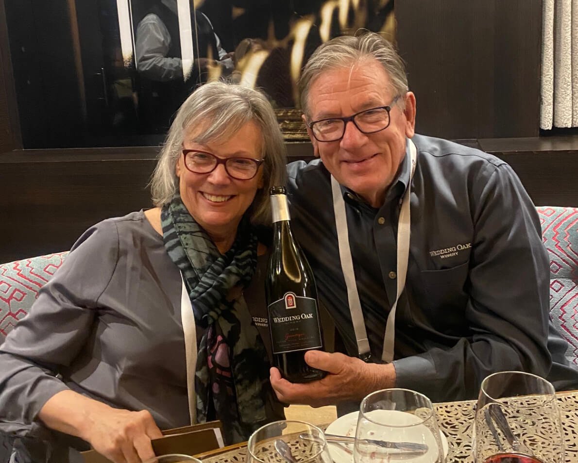 Lynn and Mike McHenry holding a bottle of Wedding Oak wine